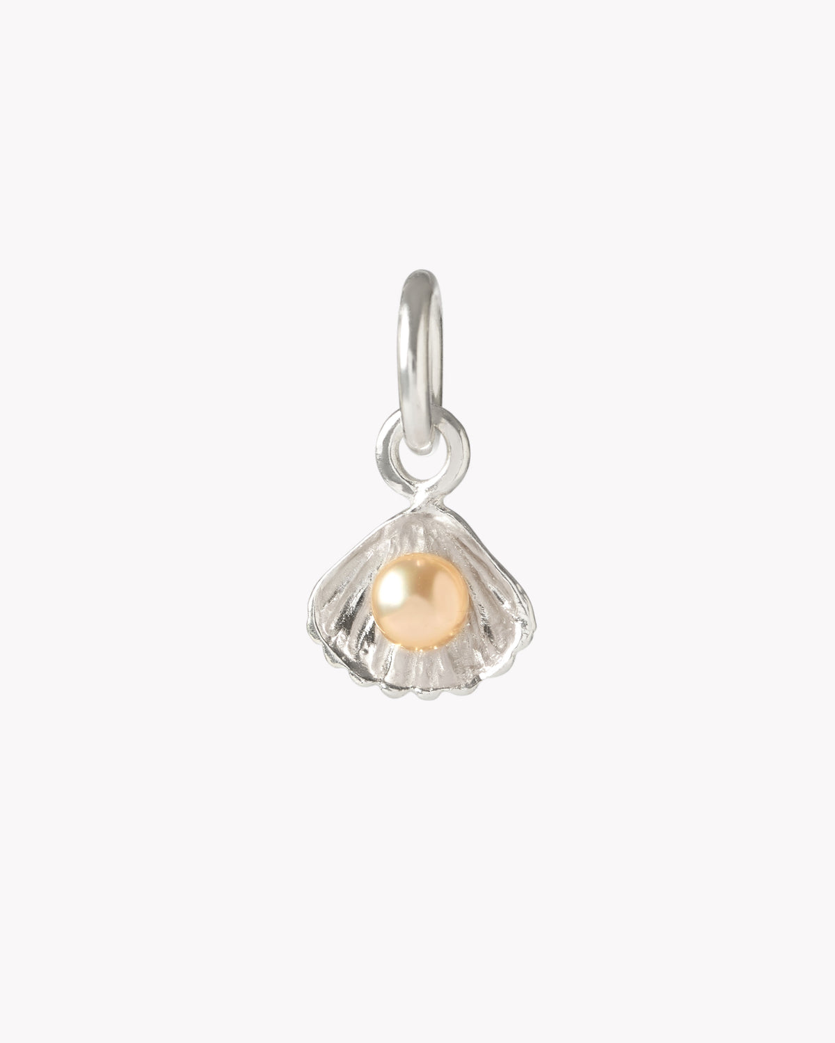 Close-up of a golden freshwater pearl charm in a sterling silver shell setting
