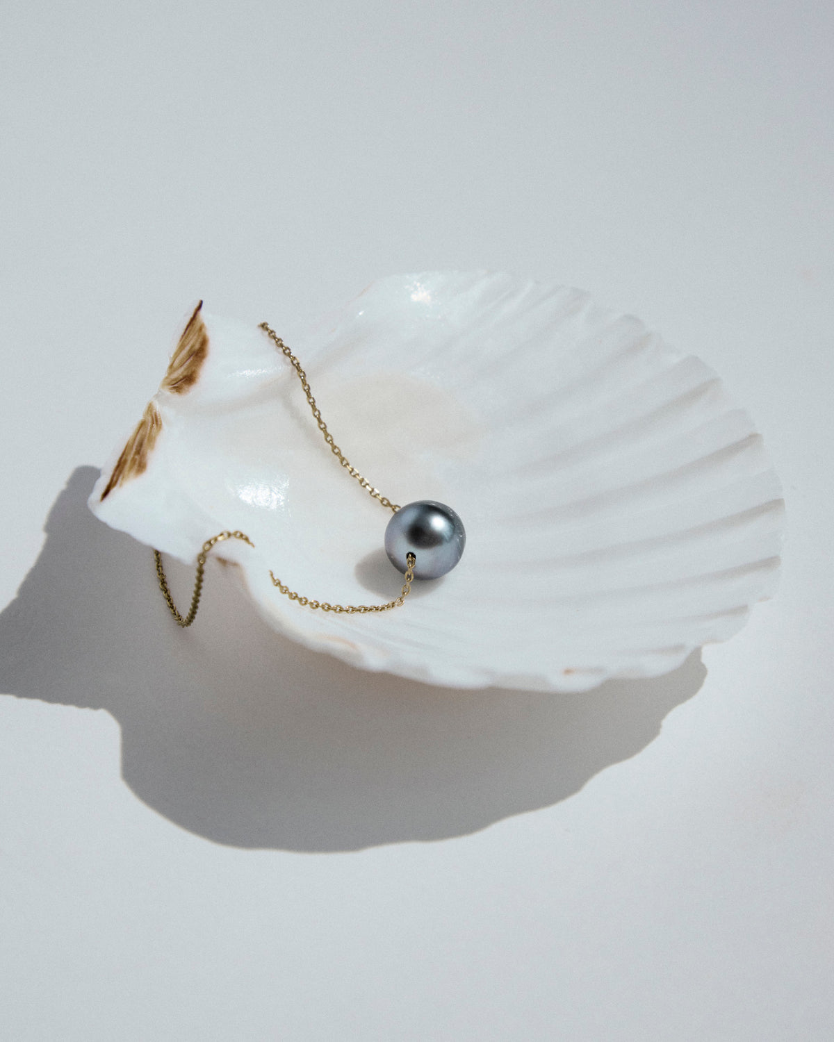Close-up of a round 12mm Tahitian pearl on the Ile Ronde 18K gold necklace