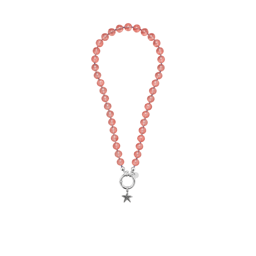 A beaded necklace featuring round, translucent pinkish-red beads with a silver-toned clasp that forms a crescent moon and star fish  pendant, shown on a plain white background.
