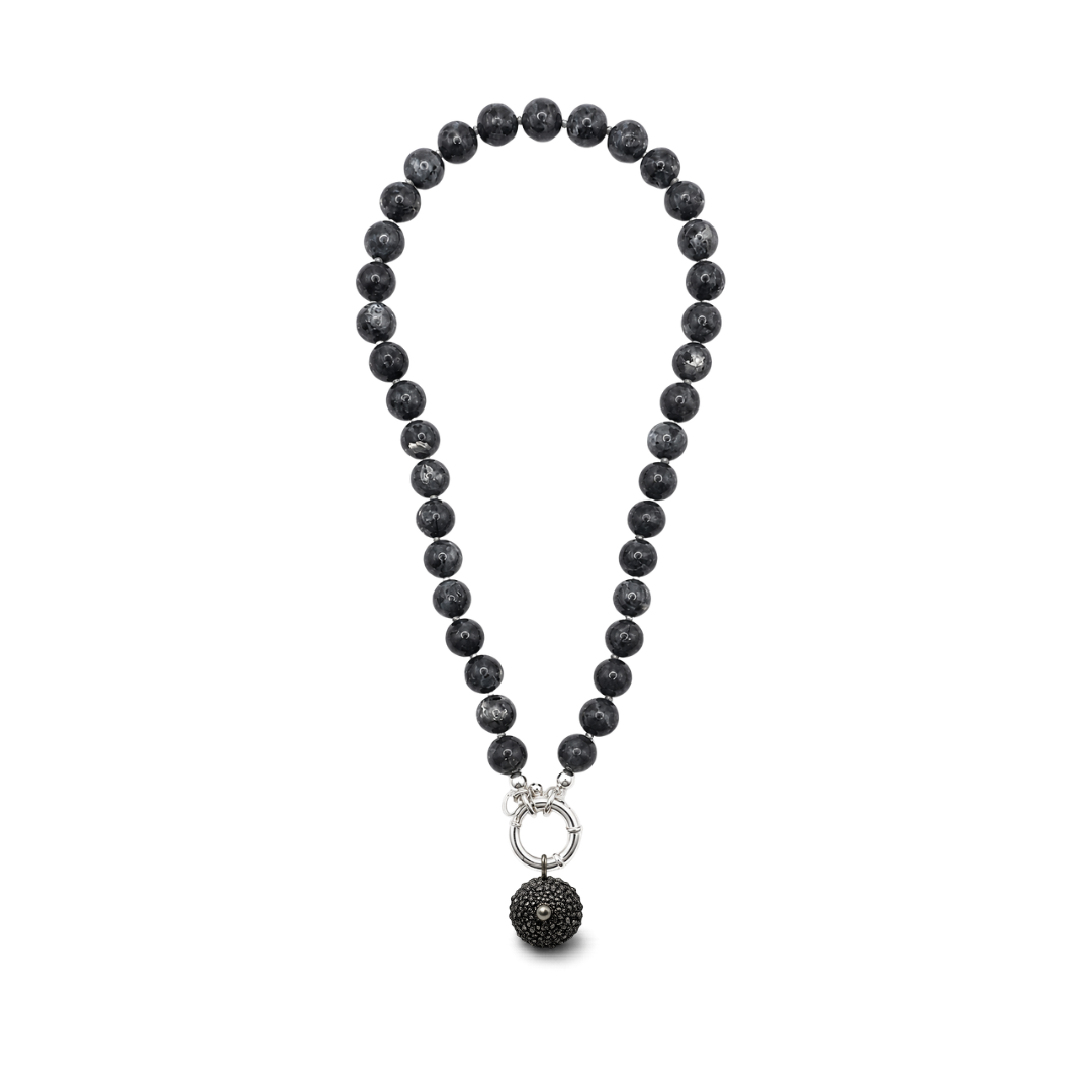 A beaded necklace made of matte black stone beads with a silver clasp  and a small sea urchin  pendant, with tahitian pearl.