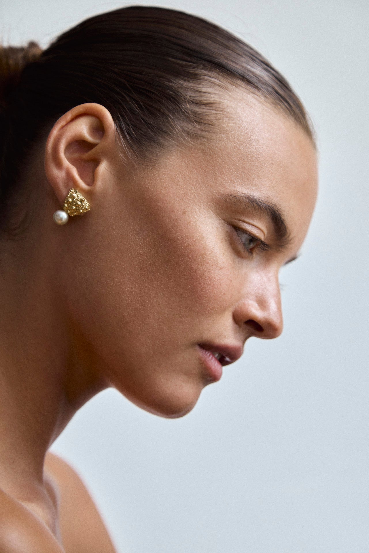 Side view of Grand Gaube sculptural 18K gold earrings with South Sea golden pearl