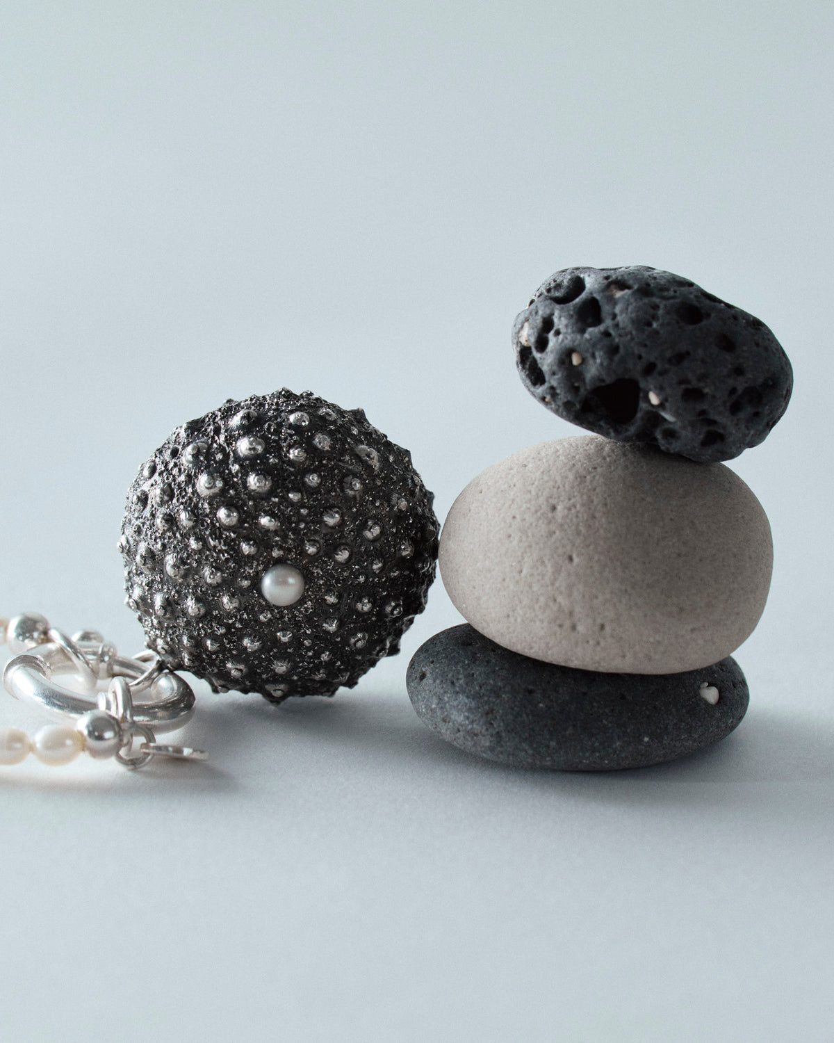 Detail of Oceano oxidised sea urchin pendant with lustrous white pearl.