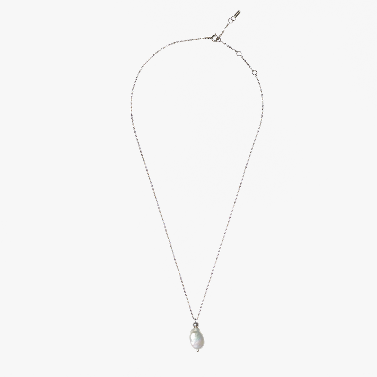 Close-up of Ile D'Ambre silver necklace featuring a luminous white freshwater flat pearl
