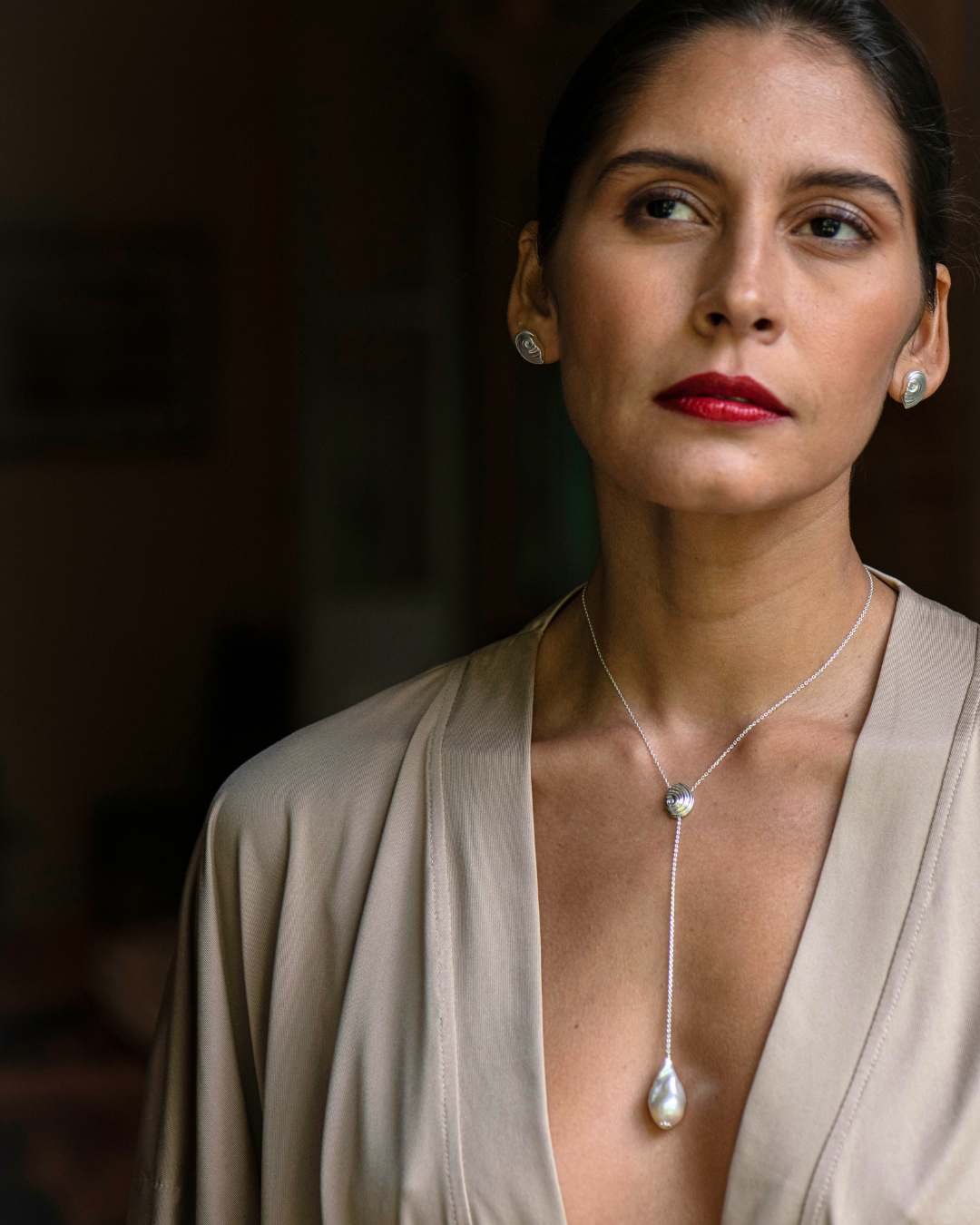 Close-up of Trou d'Eau Douce silver necklace featuring a shell charm and 9mm white freshwater pearl