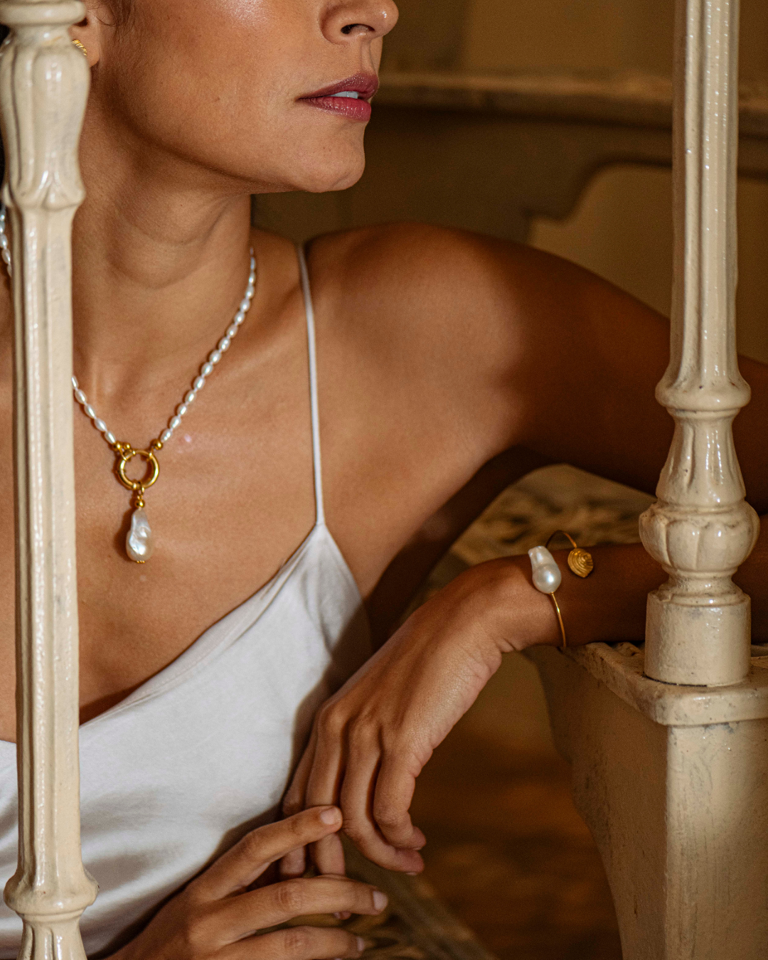 Close-up of the baroque pearl and gold spiral detail on the Trou d'eau Douce bracelet